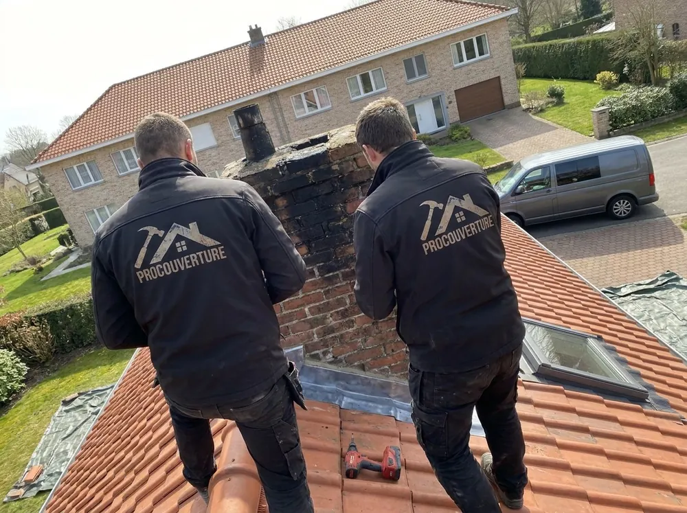 Deux couvreurs ProCouverture au pied d’une souche de cheminée